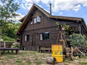 東野さんのカントリーなログハウスの全景。折れた形の屋根が大のお気に入り。裏庭も広々