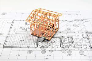 図面の上に家の模型が乗っている画像