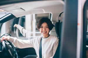 女性が車のハンドルを持っている画像