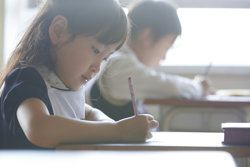 2人の子供が机で勉強している画像