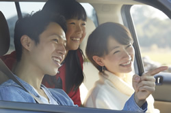 男性と女性と子供が車に乗っている画像